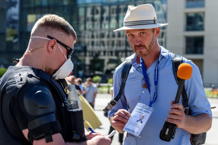 Der sich selbst "Volkslehrer" nennende Nikolai Nerling wird auf einer Demo am 1. August in Berlin von einem Polizisten kontrolliert
