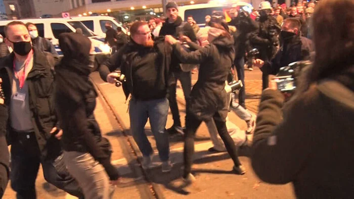 Eine Frau greift nach der Querdenken-Demo in Leipzig einen Mann an