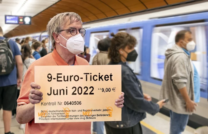 Mann hält in U-Bahn-Station überdimensionales 9-Euro-Ticket hoch