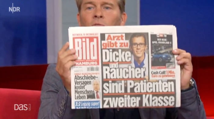 NDR-Moderator Hinnerk Baumgarten hält eine "Bild"-Zeitung hoch