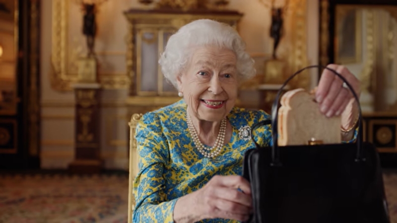 Queen Elizabeth holt in einem Imagefilm mit Paddington Bär ein Brot aus ihrer Handtasche