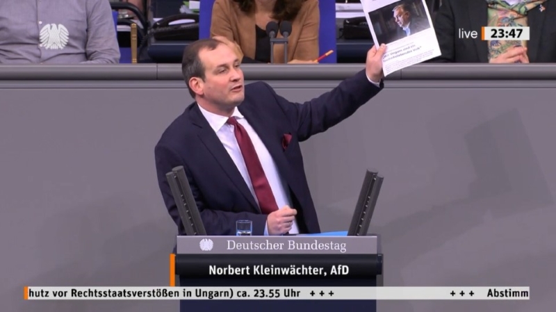 Bundestagsabgeordneter Norbert Kleinwächter (AfD) bei einer Rede im Parlament. Er wedelt mit einem Ausdruck des Orbán-Interviews in der "Budapester Zeitung"