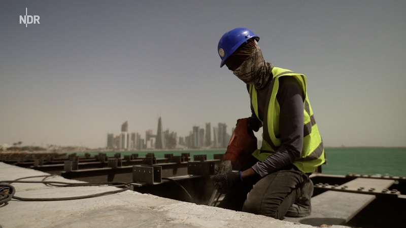 Bauarbeiter vor der Kulisse von Doha