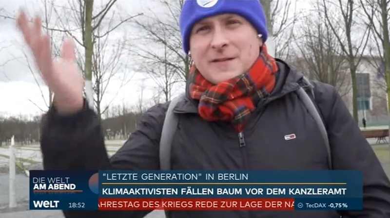 Mann mit AfD-Mütze vor dem Kanzleramt in Berlin.