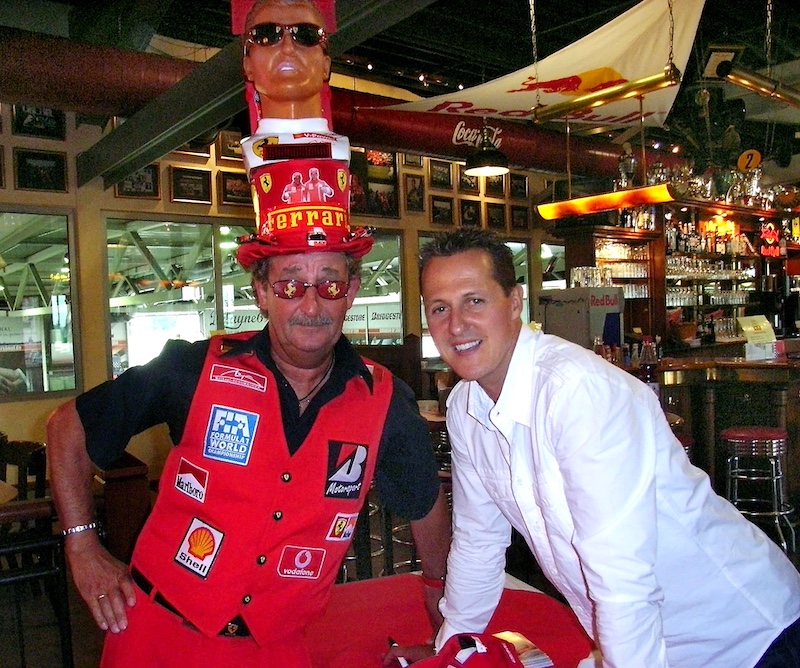 Reiner Ferling (links) vom Schumacher-Fanclub, in Fan-Montur und mit Schumacher-Zylinder, neben Michael Schumacher.