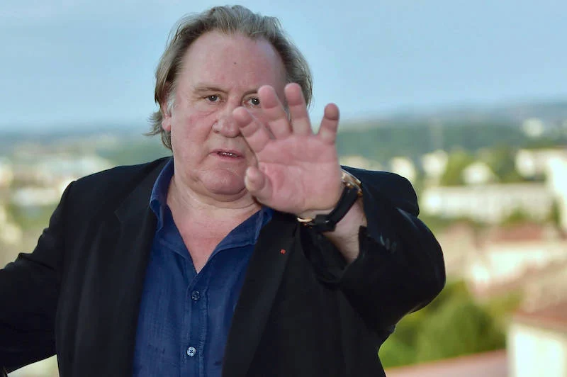 Gérard Depardieu macht abwehrende Geste mit der flachen Hand Richtung Kamera.