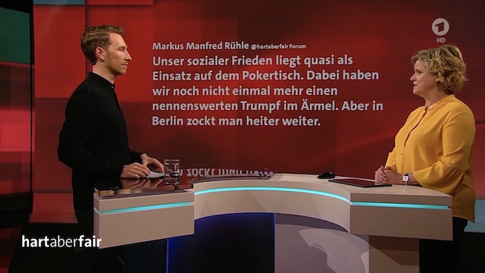 Screenshot aus der Sendung "hart aber fair": Moderator Louis Klamroth und Brigitte Büscher stehen an einem Tisch, dahinter eingeblendet: ein Kommentar eines Zuschauers.