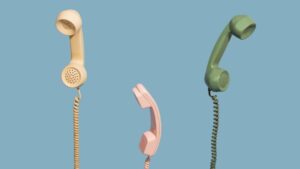 Drei alte Telefonhörer am Kabel.