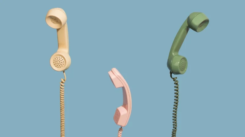 Drei alte Telefonhörer am Kabel.