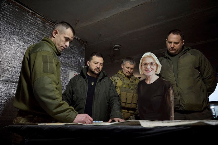 Montage: Tanja May steht strahlend neben Wolodymyr Selenskyj und Soldaten an einem Tisch bei einer Besprechung.
