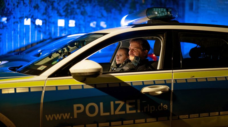 Polizeiwagen mit zwei Polizisten - Ausschnitt aus "Nachtstreife"