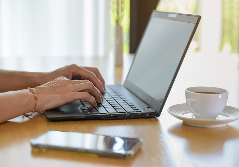 Nahaufnahme von Händen auf einer Laptoptastatur