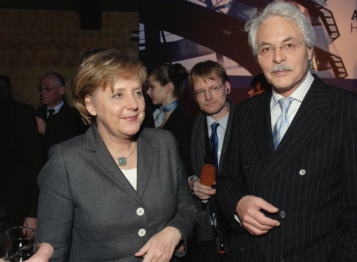 Jörg Wagner steht etwa einen Meter hinter Ex-Bundeskanzlerin Angela Merkel und ARD-Moderator Thomas Roth.