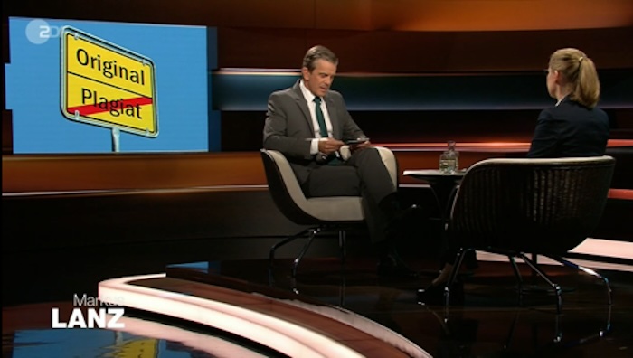 Markus Lanz sitzt der Juristin Frauke Brosius-Gersdorf gegenüber. Im Hintergrund: ein Schild im Stil von Ortsschildern. Oben steht „Original“, unten – rot durchgestrichen – „Plagiat“.