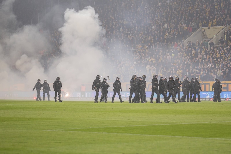 Polizei auf dem Spielfeld im Stadion von Dynamo Dresden am 4.4.2026, im Hintergrund viel Rauch.