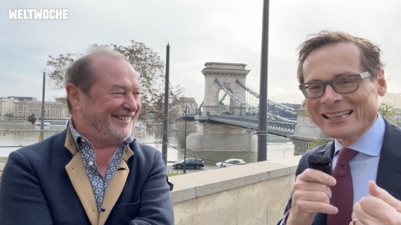 Kurt W. Zimmermann und Roger Köppel stehen in Budapest und unterhalten sich, im Hintergrund die Donau.