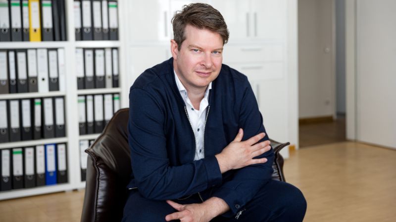 Generationenforscher Rüdiger Maas vor einem Regal mit Ordnern