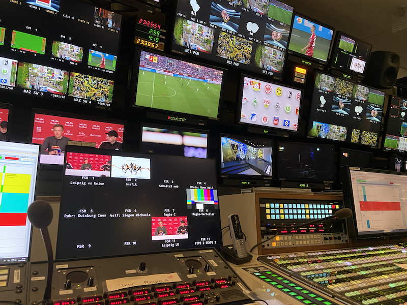 Regieraum der „Sportschau“: Viele Bildschirme mit unterschiedlichen Bildern, darunter Mischpulte
