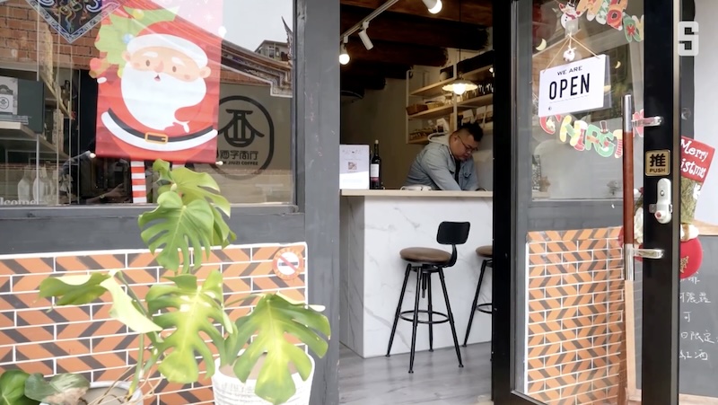 Blick in eine Kaffeerösterei auf Kinmen. Hinter der Theke steht der Besitzer.