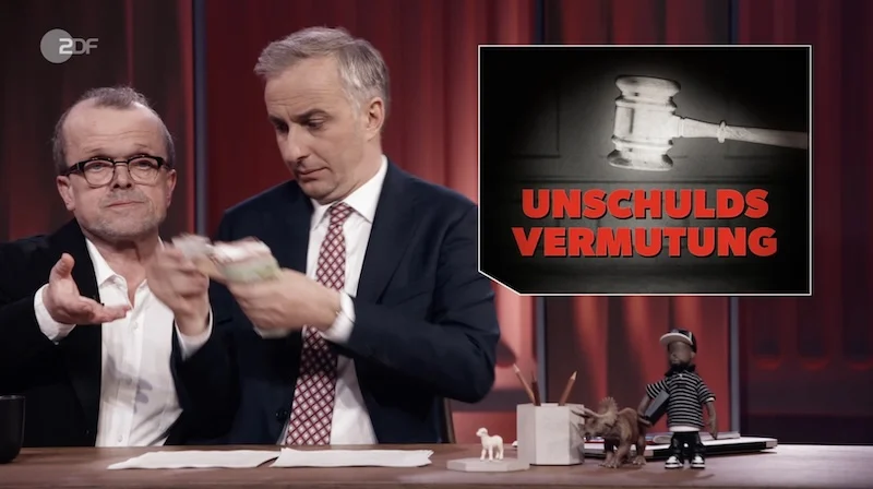 Szene auf dem „ZDF Magazin Royale“ vom 17.4.2026: Jan Böhmermann zählt Geldscheine in die Hand des „Scherzanwalts Dr. Christian Witz“.