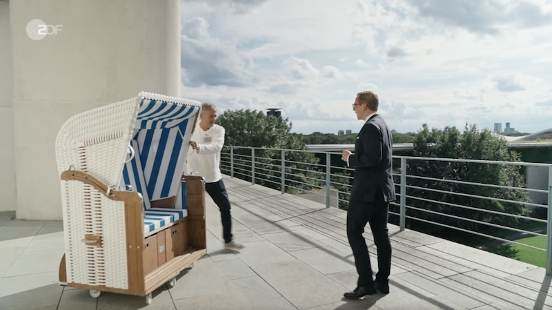 Philipp Amthor steht auf der Terrasse seines Büros im Bundeskanzleramt und nimmt einen innen blau-weiß gestreiften Strandkorb in Empfang.