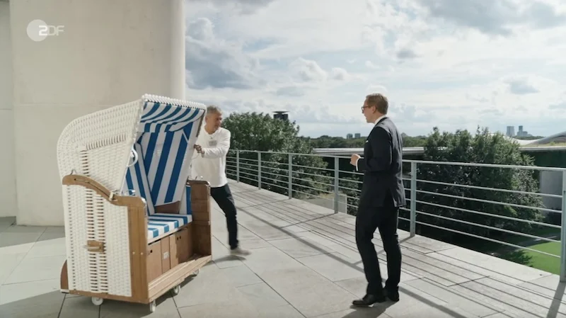 Philipp Amthor steht auf der Terrasse seines Büros im Bundeskanzleramt und nimmt einen innen blau-weiß gestreiften Strandkorb in Empfang.