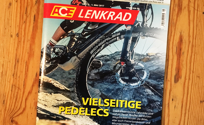 Titel der Zeitschrift "ACE Lenkrad", auf der ein Fahrrad in Nahaufnahme abgebildet ist, offenbar ein geländetaugliches Mountainbike in den Bergen. Schlagzeile: "Vielseitige Pedelecs"