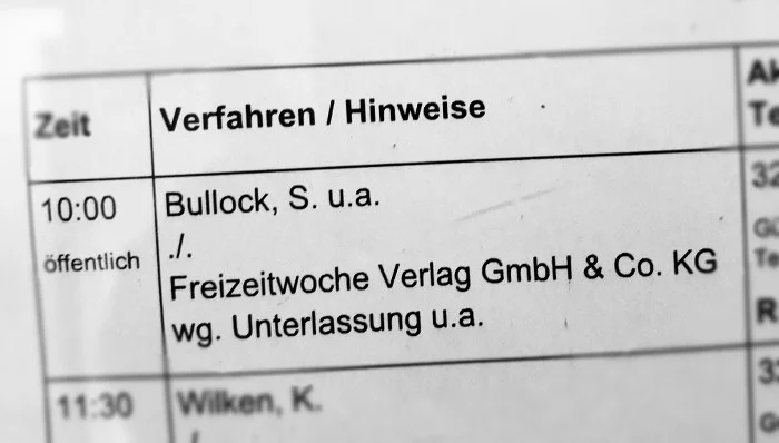 Aushang an der Tür des Verhandlungssaals mit Angaben zu den verschiedenen Parteien.