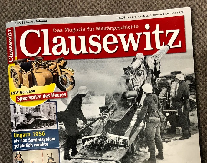 Panzer, Soldaten und ein Motorrad mit Beiwagen, auf das ein Maschinengewehr montiert ist.