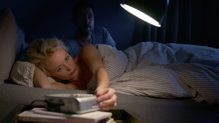Standbild aus dem Imagefilm der Funke Mediengruppe: Ein Ehepaar im Bett, es ist Morgen. Die Frau schaltet den Wecker aus, der Mann richtet sich im Hintergrund auf.