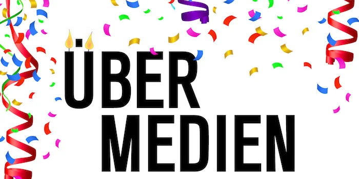 Konfettiregen über unserem Logo. Das Ü in Übermedien sieht aus wie zwei brennende Kerzen.