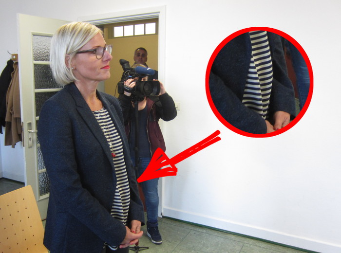 Tanja May steht in einem Saal des Hamburger Landgerichts. Sie trägt ein geringeltes Shirt, das in der Bauregion luftig geschnitten ist. 
